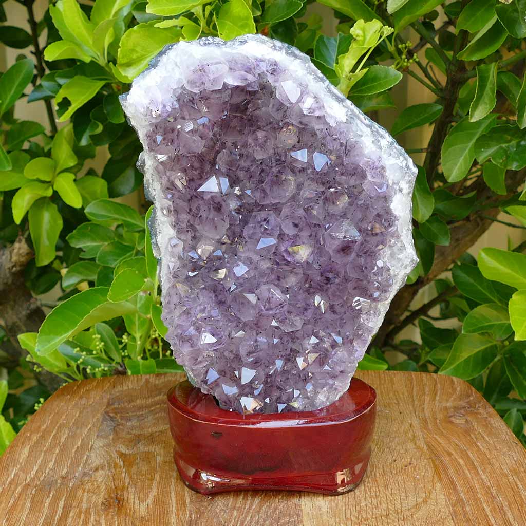 amethyst crystal cluster on wooden stand